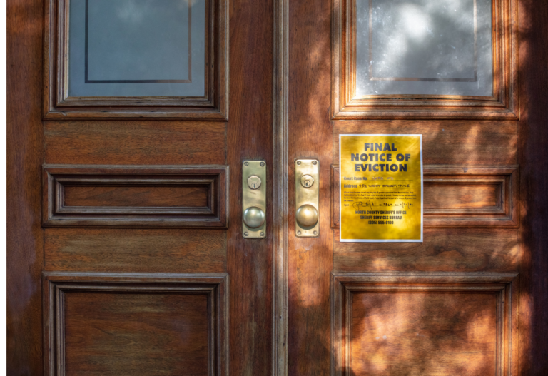 wooden doors with a yellow note on the front that reads "final notice of eviction"