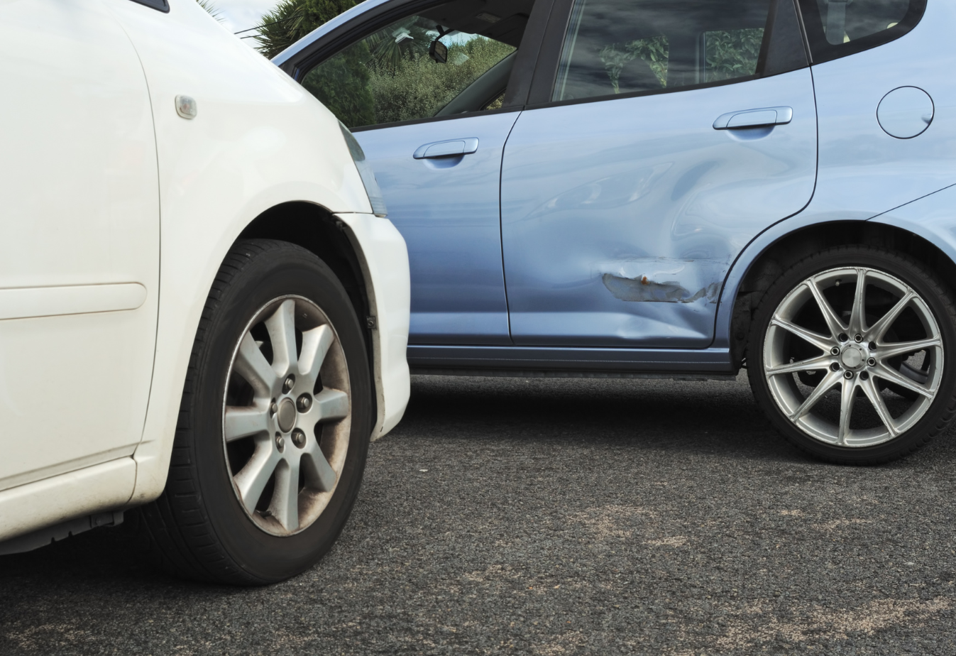a t-bone accident where a white car hit a light blue sedan