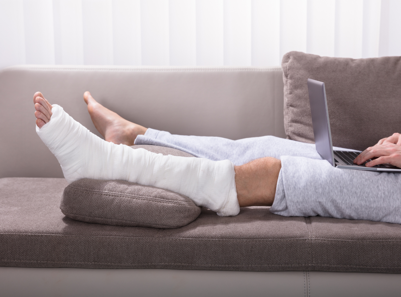a person's broken leg elevated on a couch