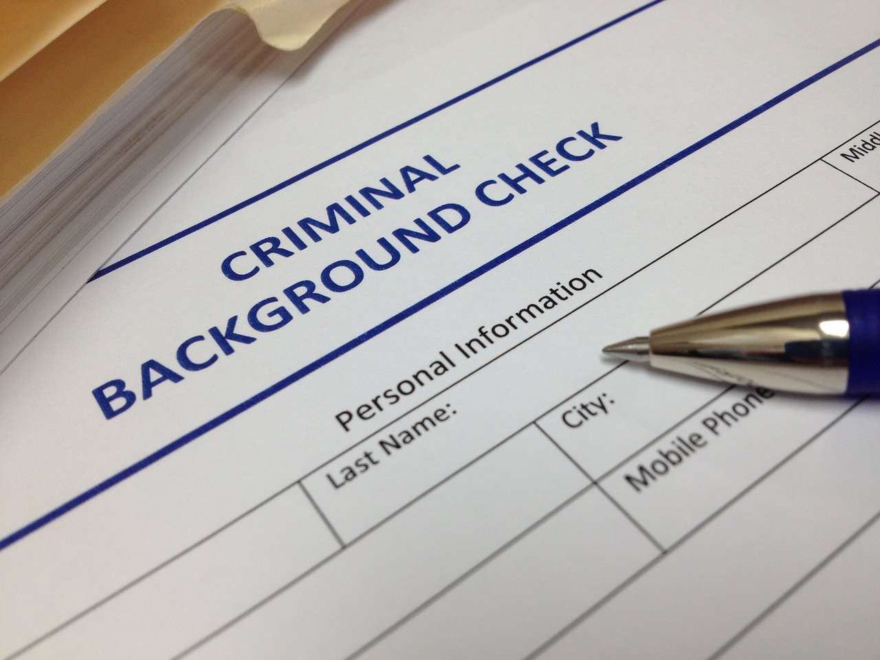 criminal background check form with a pen laying on top