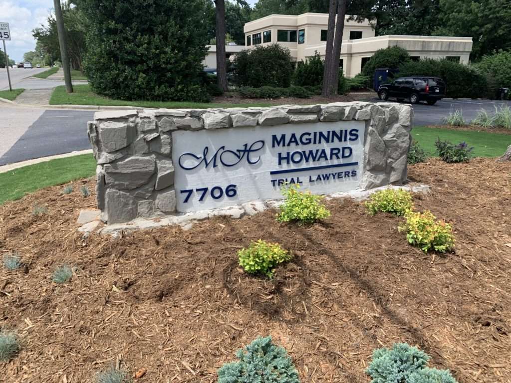 a sign reading "MH Maginnis Howard Trial Lawyers" and the number 7706 in the left hand corner
